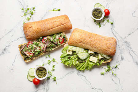 Composition with tasty sandwiches and pesto sauce on light backgroundの写真素材