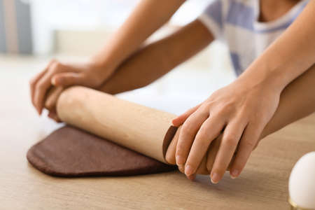 African-American little girl and her mother rolling out dough in the kitchen