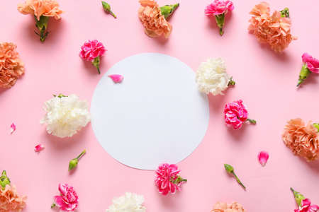 Beautiful carnation flowers and blank card on color backgroundの写真素材