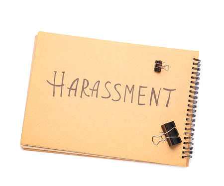 Notebook with word HARASSMENT on white backgroundの写真素材