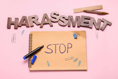 Notebook with text STOP HARASSMENT and stationery on color backgroundの写真素材