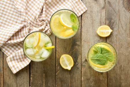 Glasses of tasty cold lemonade on wooden backgroundの写真素材