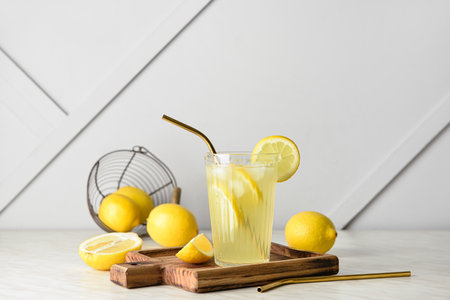 Composition with glass of tasty cold lemonade and fruits on tableの写真素材