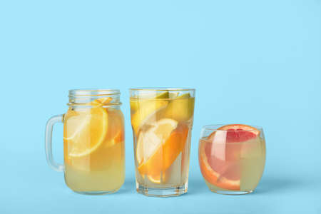 Glasses and mason jar of lemonade on color backgroundの写真素材