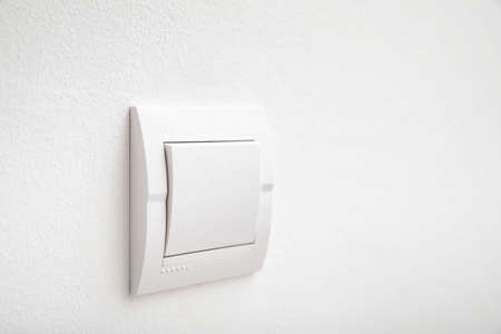 Modern light switch on white wall