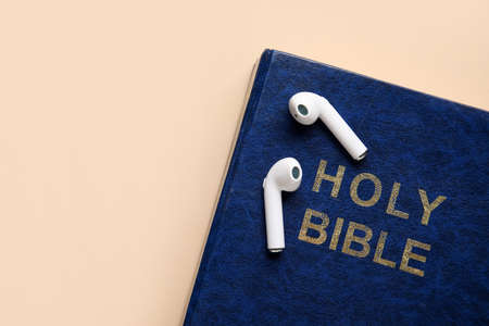 Holy Bible and earphones on color background, closeupの写真素材