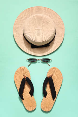 Stylish beach hat with sunglasses and flip-flops on color backgroundの写真素材