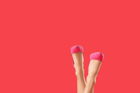Legs of beautiful woman in high heels on color backgroundの写真素材