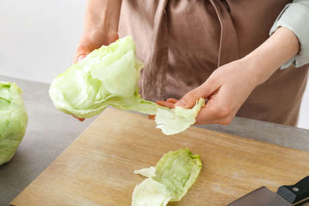 Woman with iceberg lettuce on light backgroundの写真素材
