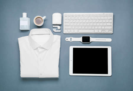 Composition with classic shirt, gadgets and cup of coffee on color backgroundの写真素材