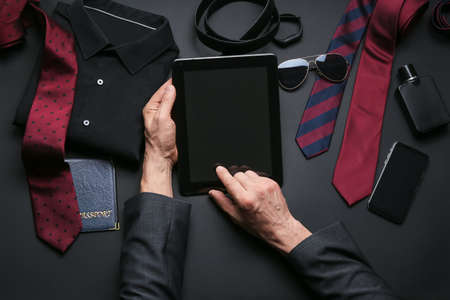 Businessman using tablet computer on dark backgroundの写真素材