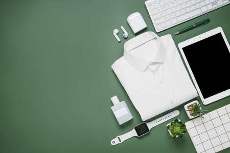 Stylish shirt and modern gadgets on color background