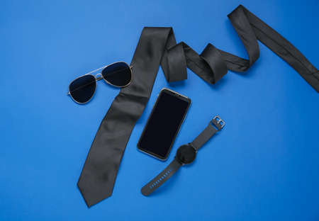 Stylish male accessories, mobile phone and smartwatch on color backgroundの写真素材