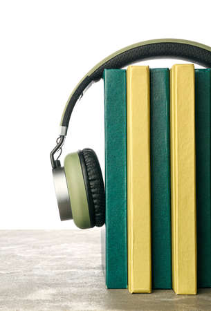 Modern headphones with books on table against white backgroundの写真素材