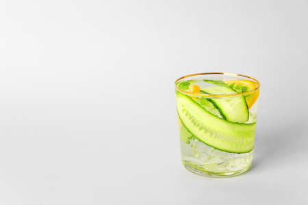 Glass with cucumber lemonade on light backgroundの写真素材