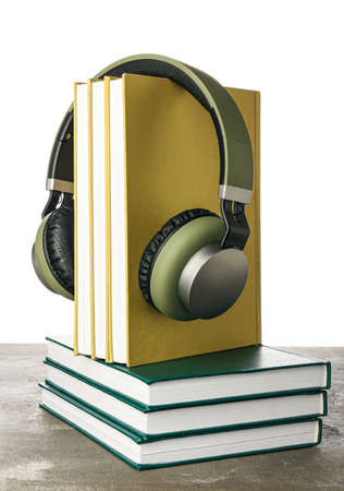 Modern headphones with books on table against white backgroundの写真素材