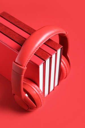 Modern headphones with books on color backgroundの写真素材