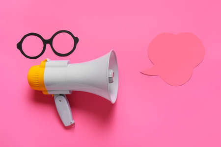 Megaphone with drawn eyeglasses and speech bubble on color backgroundの写真素材