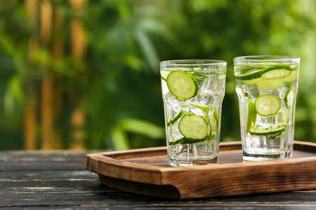 Glasses of cucumber lemonade on table outdoorsの写真素材