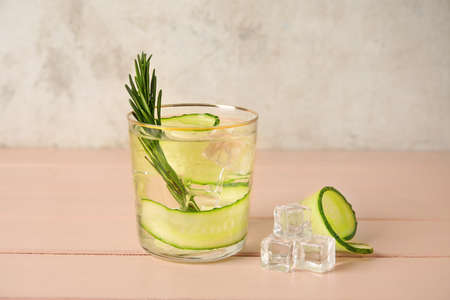Glass with cucumber lemonade on wooden backgroundの写真素材