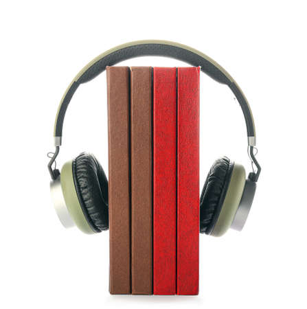 Modern headphones with books on white background