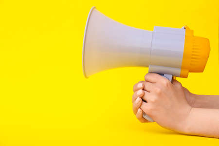 Woman with megaphone on color backgroundの写真素材
