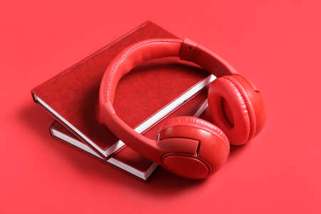 Modern headphones with books on color backgroundの写真素材