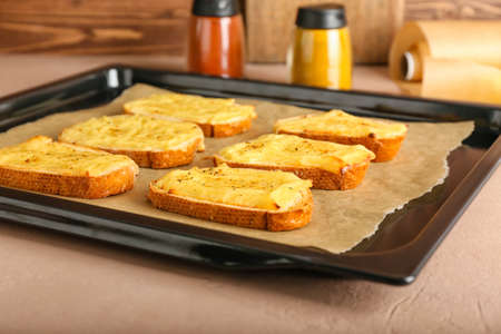 Baking sheet with tasty toasts on kitchen table