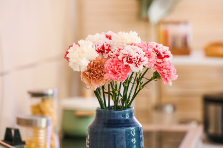 Vase with beautiful carnations in the kitchen
