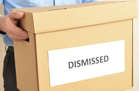 Man holding box with word DISMISSED, closeupの写真素材