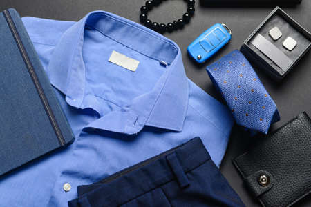 Set of stylish male accessories and clothes on dark background