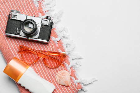 Set of beach accessories, sunscreen and photo camera on white background, closeup
