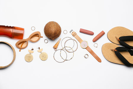 Set of female accessories, sunscreen and coconut on white background