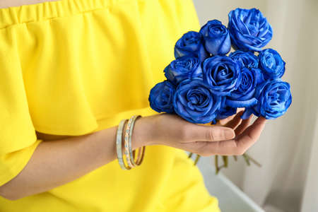 Woman with beautiful blue roses at home, closeupの写真素材