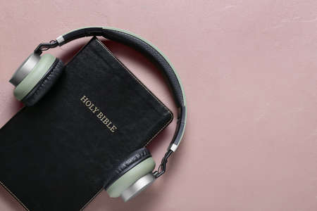 Holy Bible and modern headphones on color backgroundの写真素材