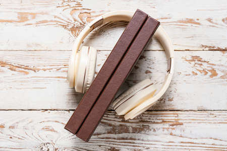 Modern headphones and books on light wooden backgroundの写真素材