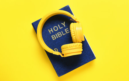 Holy Bible and modern headphones on color backgroundの写真素材