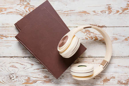 Modern headphones and books on light wooden backgroundの写真素材
