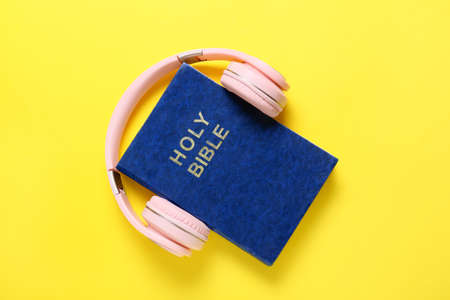 Holy Bible and modern headphones on color backgroundの写真素材