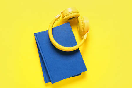 Modern headphones and books on color backgroundの写真素材