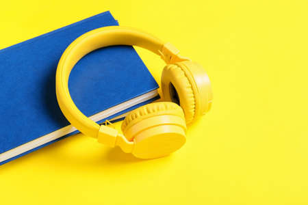 Modern headphones and books on color backgroundの写真素材