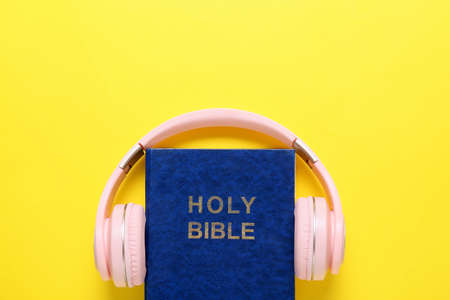 Holy Bible and modern headphones on color backgroundの写真素材