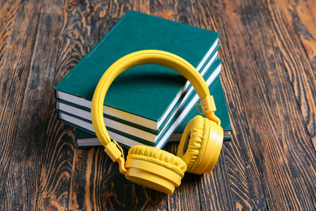 Modern headphones and books on wooden backgroundの写真素材