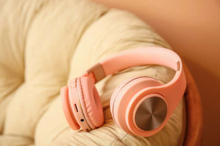 Modern headphones on armchair in roomの写真素材
