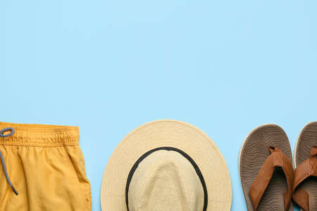 Stylish hat, shorts and flip-flops on color backgroundの写真素材