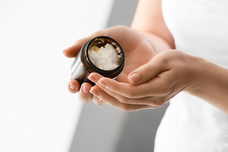 Woman holding jar with shea butter, closeupの写真素材