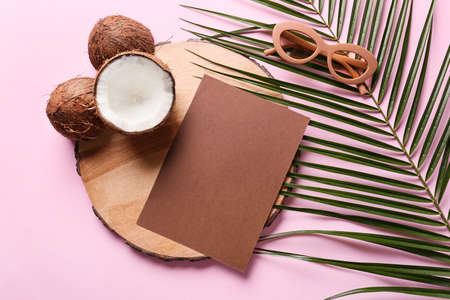 Composition with blank card, coconuts, sunglasses and palm leaf on color backgroundの写真素材