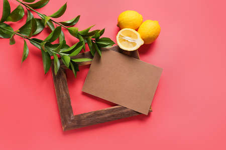 Composition with blank card, empty picture frame, lemons and plant branches on color backgroundの写真素材