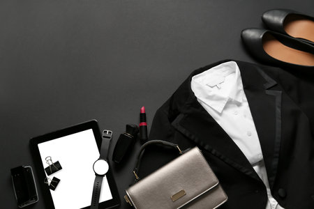 Stylish female clothes, accessories and tablet computer on dark backgroundの写真素材