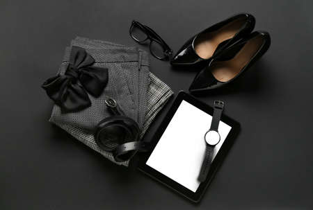 Stylish female clothes, accessories and tablet computer on dark backgroundの写真素材